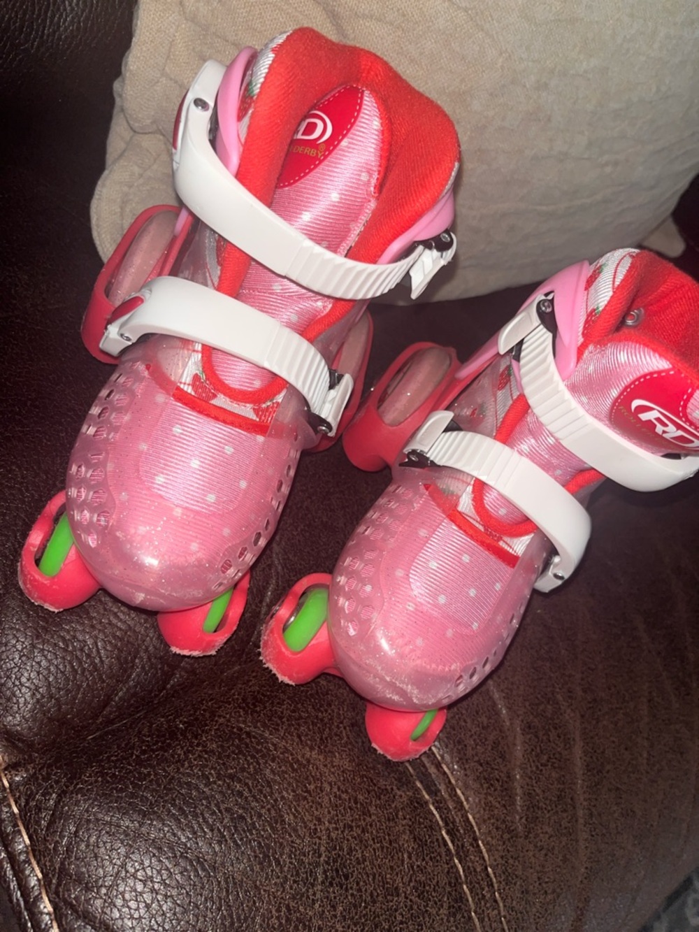 Pink Adjustable Kids Roller Skates with Strawberry Wheel Accents and kneepads.